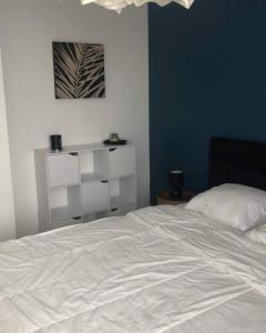 a bedroom with a white bed and a blue wall at Appartement T2 Bayonne avec parking in Bayonne