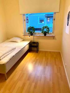 a bedroom with a bed and a window with two plants at Mysigt hus med 9 sovrum nära natur och SCA & Hamn in Holmsund