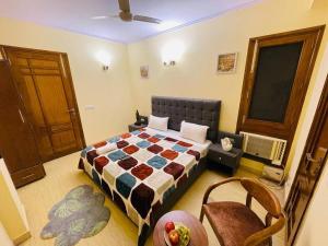 een slaapkamer met een bed en stoelen in een kamer bij Fortune Home Service Apartment 4Bhk,D-36, Saket in New Delhi
