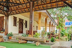 a pavilion with wooden posts and trees and plants at Capital O 93345 The Saka Guest House Syariah in Bandar Lampung