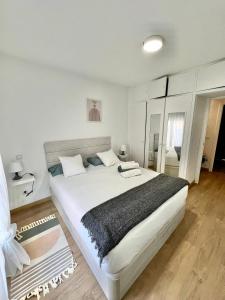 1 dormitorio con 1 cama blanca grande y 1 alfombra en Casa Dalla, en Miraflores de la Sierra