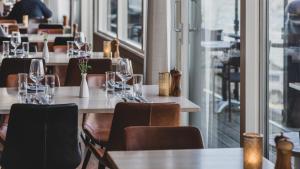 a restaurant with tables and chairs with wine glasses at Quality Hotel Waterfront in Gothenburg