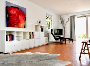 a living room with white cabinets and a painting on the wall at Kustverhuur, Park Scheldeveste Zwin 010 in Breskens