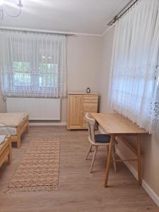 Habitación con escritorio, mesa y ventana. en Skrawek Nieba Mostki, en Suchedniów