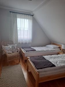 Habitación con 2 camas, silla y ventana en Skrawek Nieba Mostki, en Suchedniów