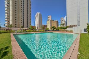 a swimming pool in a city with tall buildings at Apartamento Natsu - PlusHolidays in Calpe