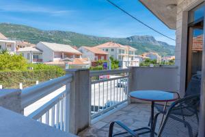 a balcony with a table and chairs and mountains at By the sea West Apartments in Kaštela
