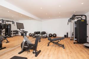 a gym with several exercise equipment in a room at Mangia's Santa Teresa Sardinia, Curio Collection by Hilton in Santa Teresa Gallura