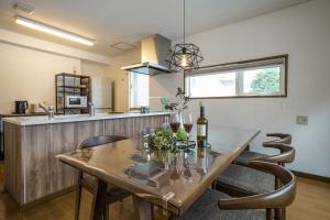 a dining room with a table with wine bottles and chairs at Canal Villa Otaru - Vacation STAY 99697v in Otaru