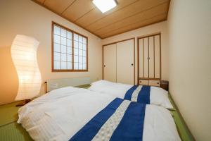ein Schlafzimmer mit einem großen Bett in einem Zimmer mit Fenstern in der Unterkunft Canal Villa Otaru - Vacation STAY 99697v in Otaru