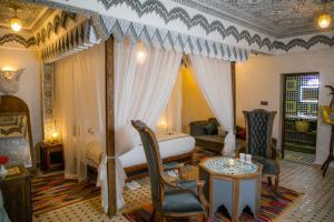 um quarto com uma cama, um sofá e uma mesa em Ksar Elkabbaba Kasbah & SPA em Skoura