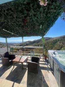 a patio with a table and chairs and a swimming pool at Casa Rural Málaga Monkey Love con jacuzzi in Iznate