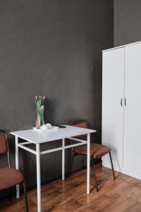 塞米伊的住宿－歐洲酒店，一张带椅子的白色桌子和花瓶