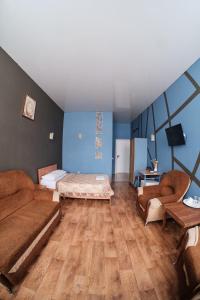 a room with two beds and a desk and a tv at Hotel Europa in Semey