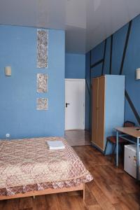 1 dormitorio con cama y pared azul en Hotel Europa, en Semey