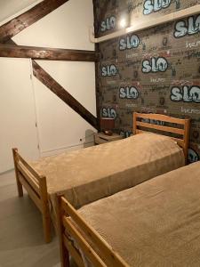 een kamer met 2 bedden en een muur met slo bierborden bij Etage privé in Blainville-sur-lʼEau