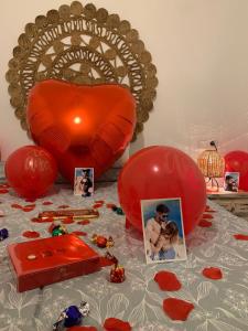 Iznate的住宿－Casa Rural Málaga Monkey Love con jacuzzi，一张桌子,上面放着红色气球和图片,还有一颗心