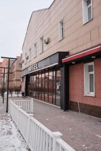 a hotel building with a white fence in front of it at Hotel Europa in Semey