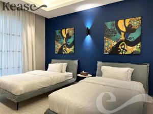 two beds in a bedroom with blue walls at Kease King Salman K-7 Lusso Najd AX14 in Riyadh