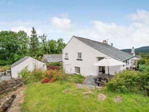 a white house with an umbrella on a hill at 4 Bed in Routenbeck SZ405 in Bassenthwaite Lake