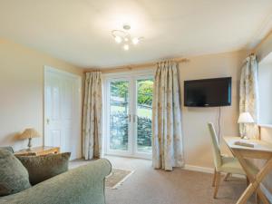 a living room with a couch and a desk and a window at 3 Bed in Thornthwaite SZ194 in Braithwaite