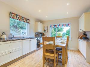 a kitchen with white cabinets and a table and chairs at 3 Bed in Thornthwaite SZ194 in Braithwaite