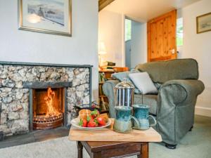 un soggiorno con camino e tavolo con cesto di frutta di 2 Bed in Borrowdale SZ302 a Rosthwaite