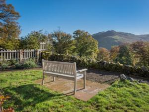 a park bench sitting in the grass near a fence at 4 Bed in Matterdale SZ367 in Dockray