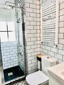 uma casa de banho branca com um chuveiro e um WC. em SG Apartamentos - LA CASA DE SOFÍA VUT-47-14 em Valladolid