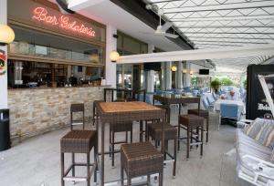 a restaurant with tables and chairs and a bar at Hotel Berna in Eraclea Mare