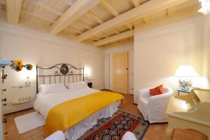 a bedroom with a large bed and a chair at Torre Del Nera Albergo diffuso & Spa in Scheggino
