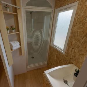 baño con ducha, lavabo y ventana en Camping Costa da Morte, en Zas