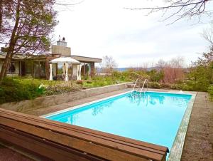 uma piscina com um banco ao lado de uma casa em Pool, Jacuzzi, Games, Nature em Adliswil