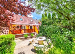 ボガーチにあるBor-Villa vendégházの木々や茂みのある庭のある黄色い家