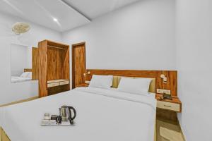 een slaapkamer met een wit bed en een machine. bij OYO Townhouse 801 The Circle in Jaipur