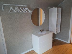 a bathroom with a white vanity and a mirror at Liten lägenhet 2 + 2 pers in Fågelfors