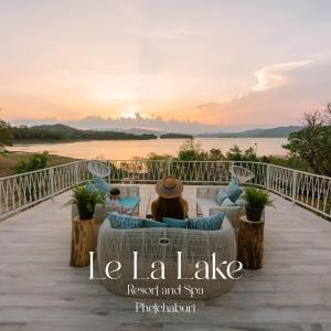 ケーンクラチャンにあるLe La Lake Resort and Spaの夕日を眺めながら甲板に腰掛けている女性