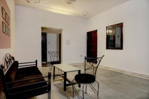 a room with a table and chairs and a couch at OYO Home Spacious Studio Sector 21-a Faridabad in Faridabad