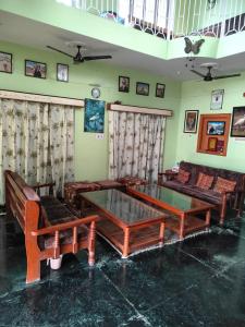 uma sala de estar com sofás e uma mesa de vidro em Hotel Spoonbbill em Bharatpur