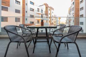 a table and four chairs on a balcony at Appartement Luxueux à Draria in Draria
