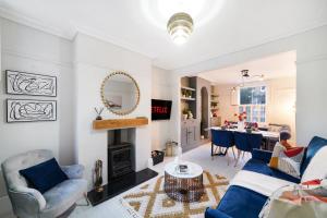 een woonkamer met een bank en een tafel bij Lux 3 Bed London House - Garden in Londen