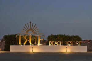 a sign for the beach resort at night at True Beach Resort in Marsa Alam City