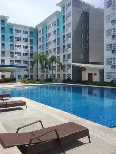 uma piscina em frente a um grande edifício de apartamentos em Comfy & Cozy em Davao