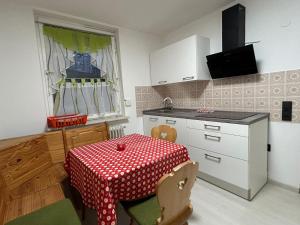 eine Küche mit einem Tisch mit einem roten und weißen Tischtuch in der Unterkunft Ferienwohnung Zucker in Grafenau