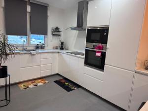 a kitchen with white cabinets and a black oven at Chez Mathieu in Saint-Dizier