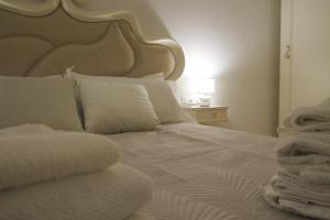 een wit bed met een groot hoofdeinde en witte kussens bij Suite Laguna in Chioggia