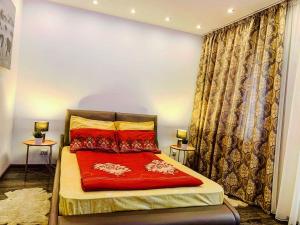 a bedroom with a bed with a red blanket at SeasonsStudioBV in Braşov