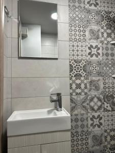 a bathroom with a sink and a mirror and tiles at Work from home Project in Thessaloniki +33 photos
