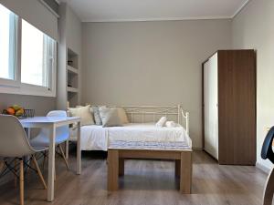 a bedroom with a bed and a desk and a table at Work from home Project in Thessaloniki