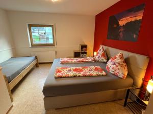 a bedroom with two beds and a couch with pillows at Gästehaus Lara in Wimbach